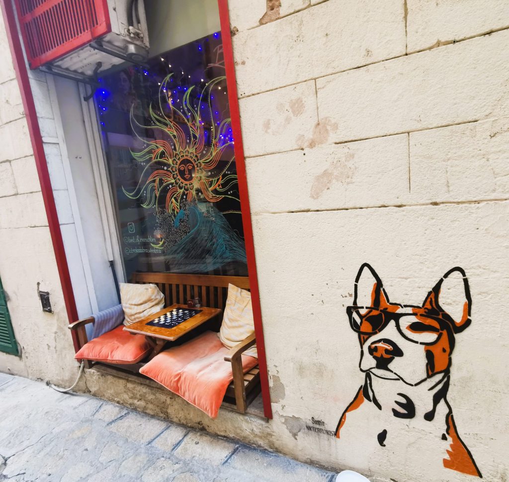 Vinothek in Palma mit Sitzplatz im Fenster und Hundegraffiti an der Wand.