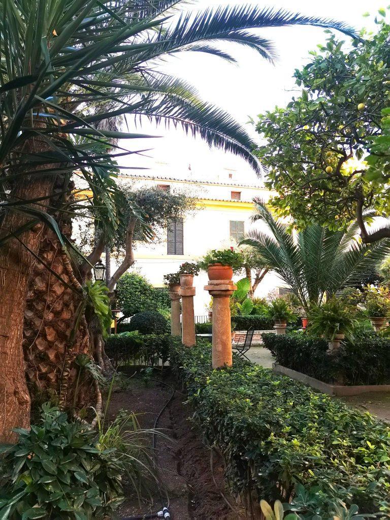 Garten der Banys Arabs mit Palmen, Sitzbänken und Säulen