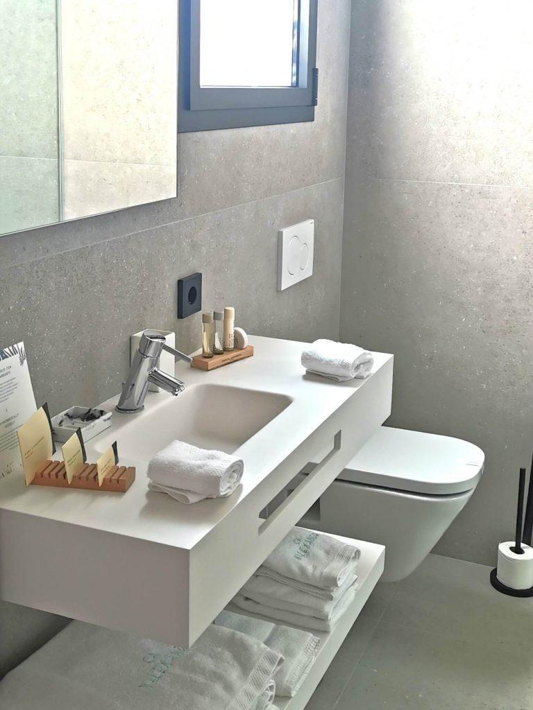 Modernes Bad im Boutiquehotel Ca'n Alexandre mit Handtüchern, Pflegeprodukten und Tageslicht