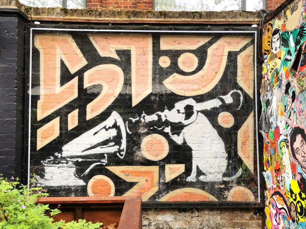 Banksy-Graffiti in London: Ein Hund mit Grammofon – kunstvolle Kritik an Medien und Kontrolle.