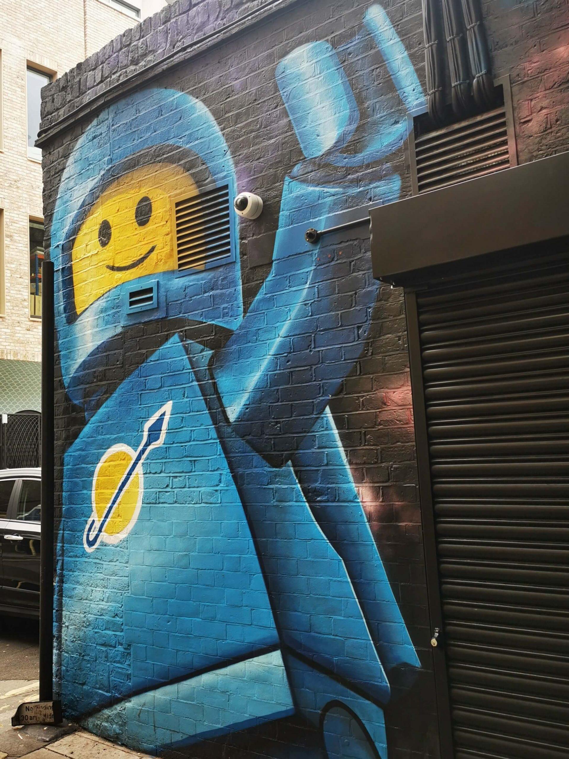 Graffiti einer Legofigur auf Hausfassade in einer Nebenstraße in London.
