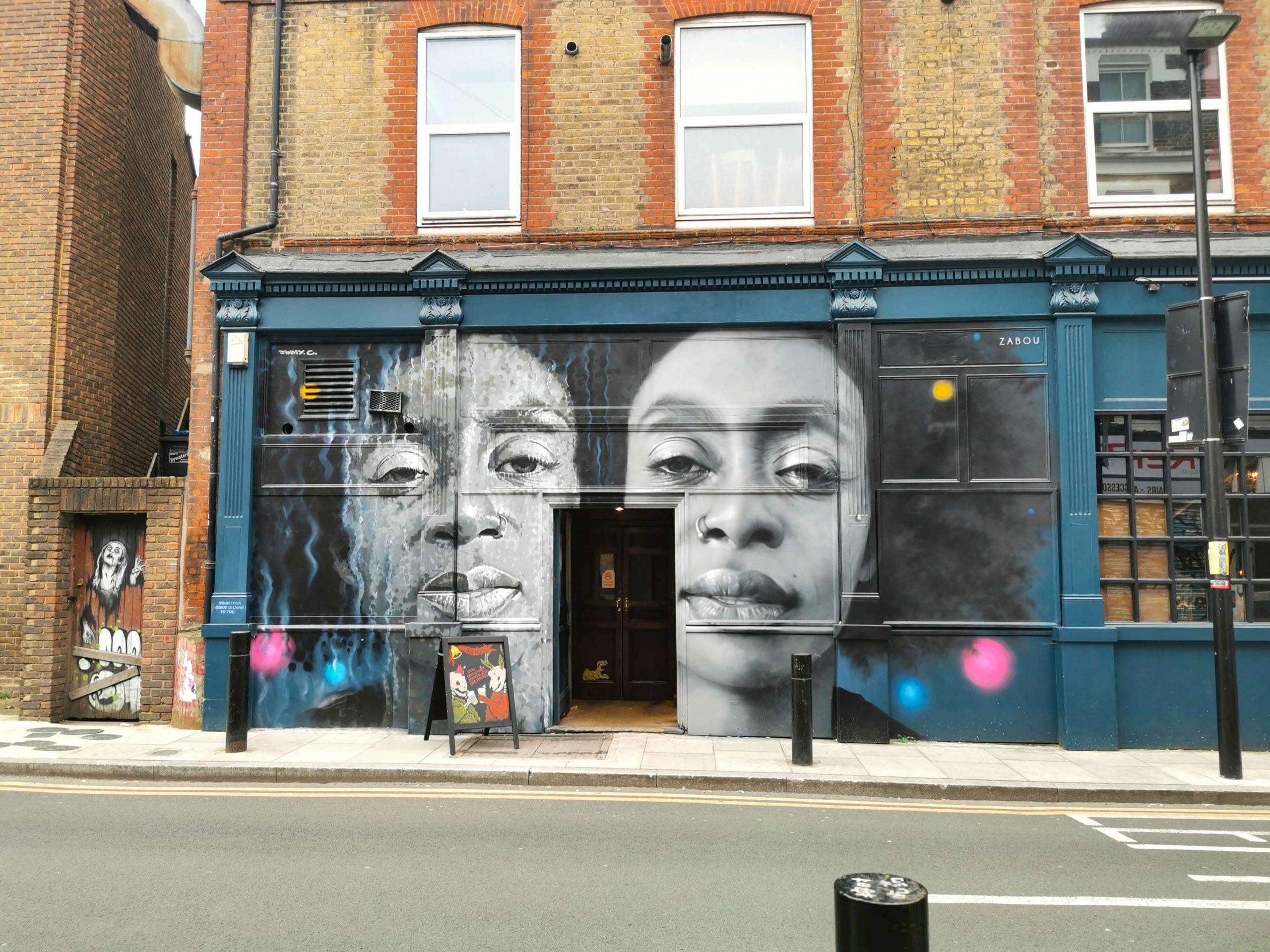 Streetart in Shoreditch, London: Großformatiges Wandgemälde zweier Gesichter in Schwarz-Weiß, von Künstlerin Zabou, auf der Fassade einer Bar