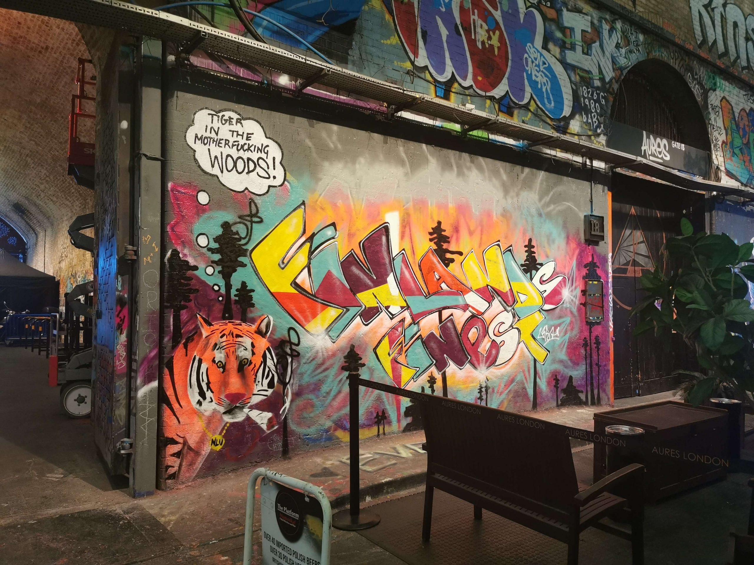 Streetart im Leake Street Tunnel in London: Ein Tiger vor buntem Graffiti mit der Sprechblase ‚Tiger in the motherfucking woods!‘