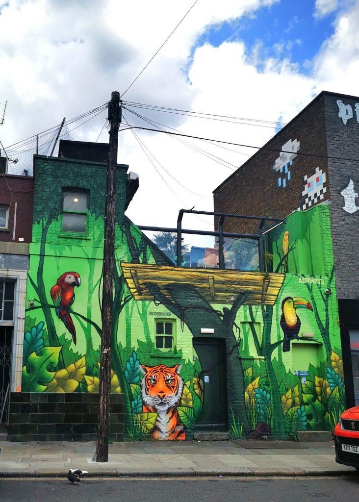 Streetart in London: Dschungelszene mit Tiger, Papageien und Tukan auf einer Hausfassade
