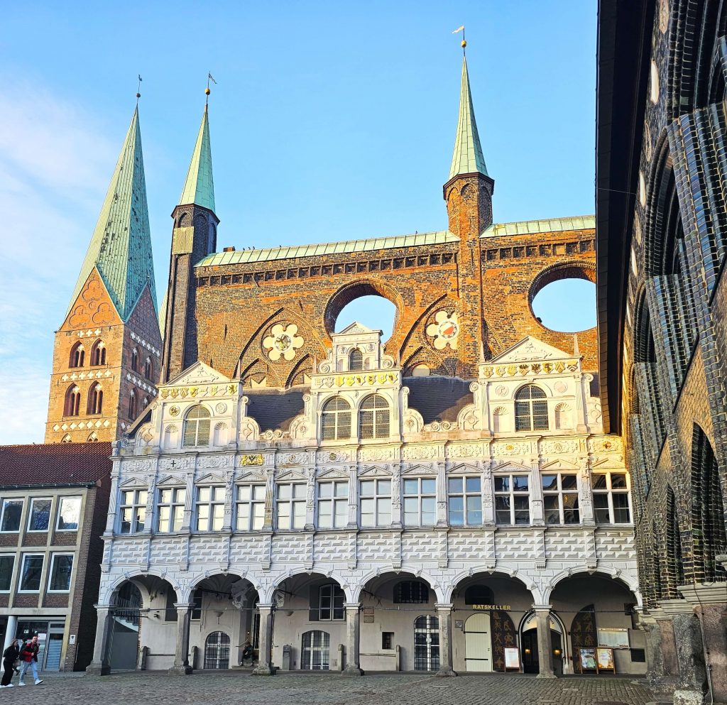 Das historische Rathaus in Lübeck mit seiner Backsteinfassade im warmen Herbstlicht – eines der beeindruckendsten Bauwerke der Altstadt.