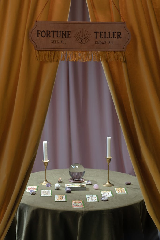 A mystical table setup with crystal ball, tarot cards, and candles for fortune telling.