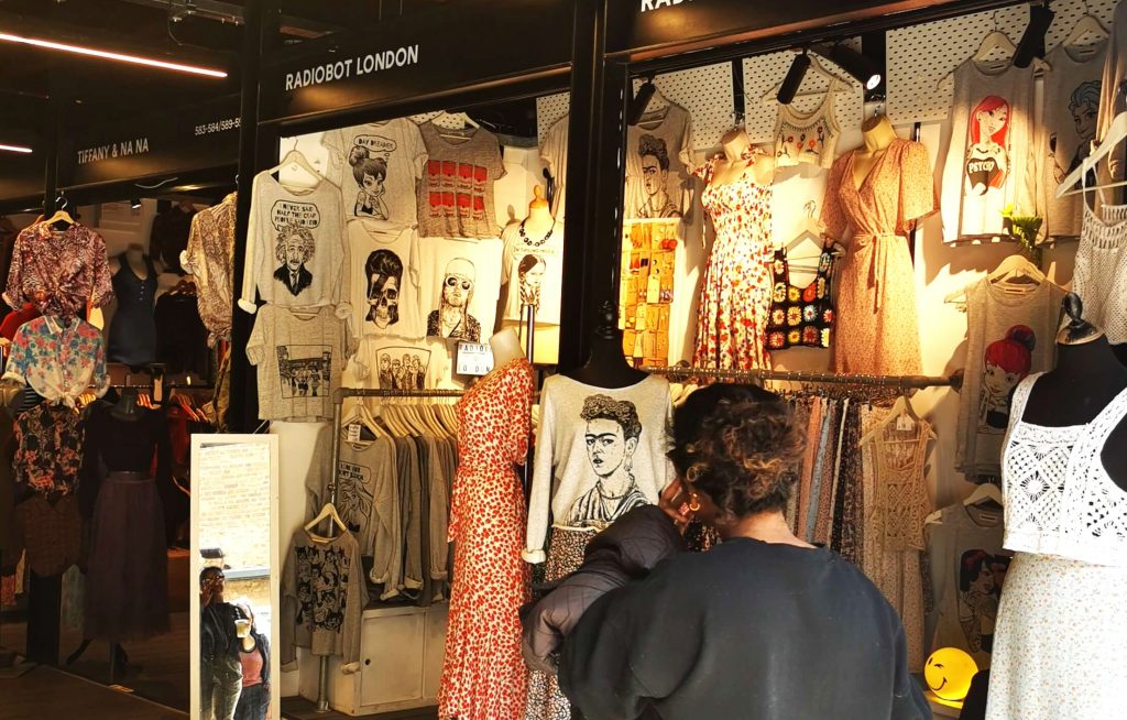 Besucherin schaut sich Kleidung in einem kleinen Shop im Camden Market London an