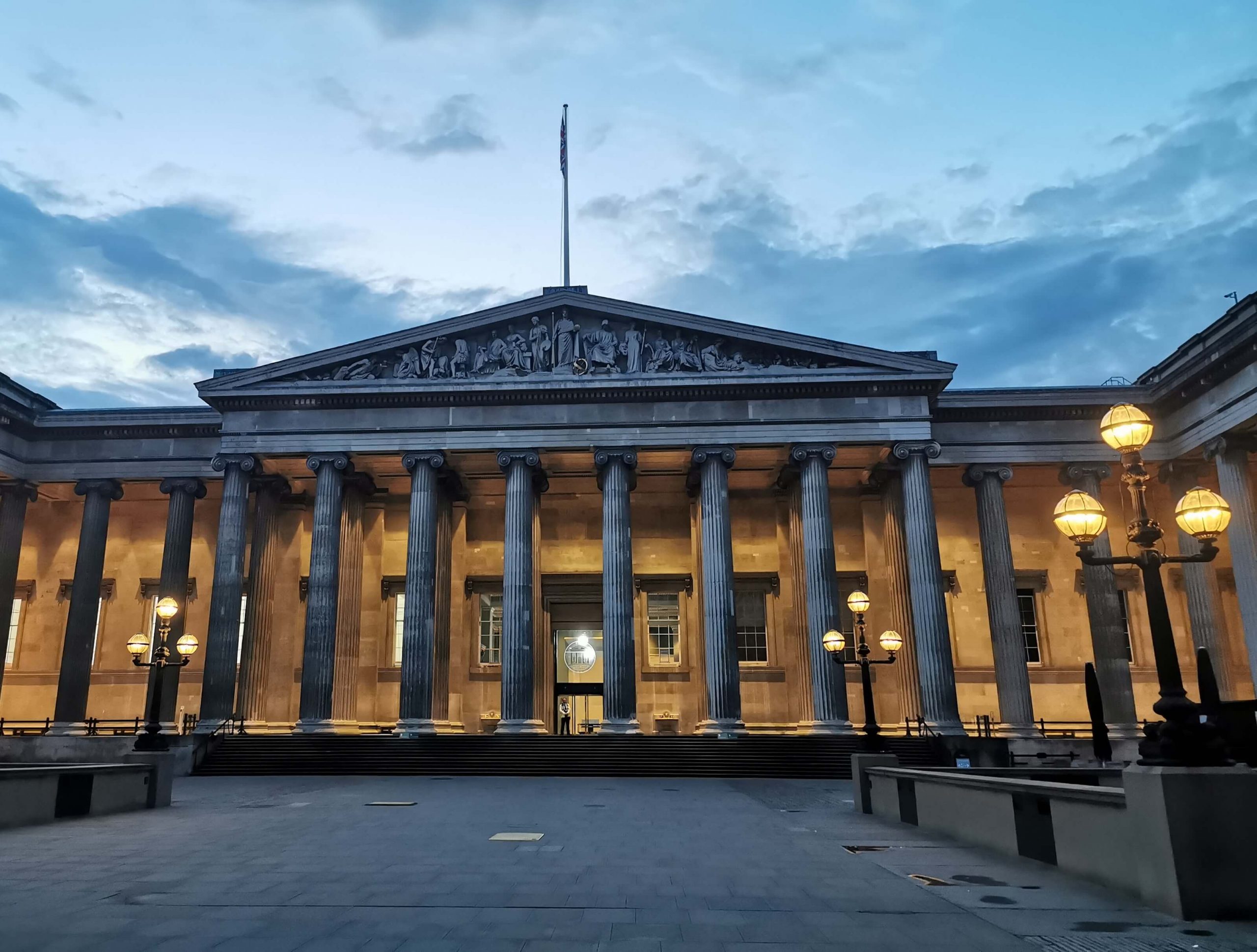 Beleuchtete Außenfassade des British Museum in London mit Säulen bei Abenddämmerung
