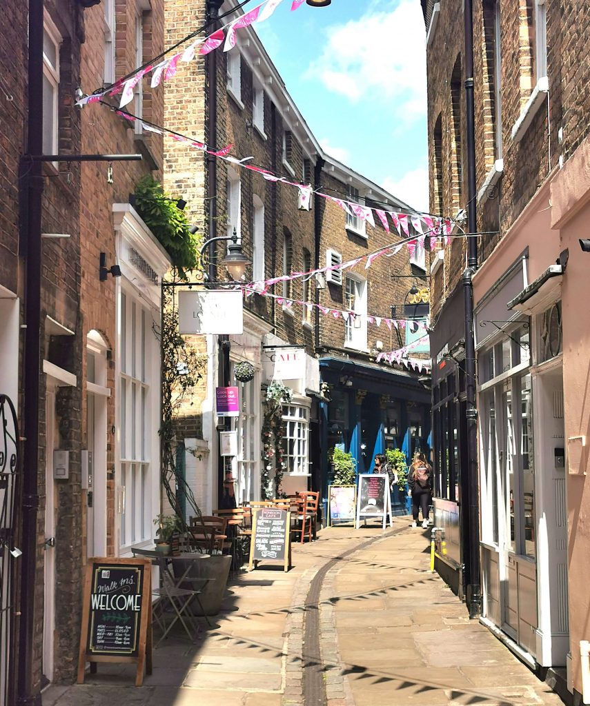 Schmale Straße mit Cafés und Dekorationen in Greenwich London