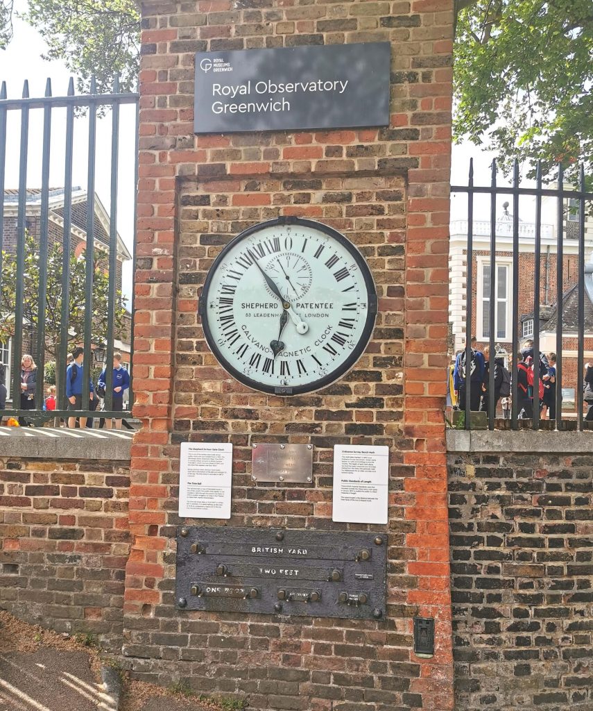 Uhr und Skala mit Feet und Yard am Nullmeridian vor dem Royal Observatory in Greenwich London