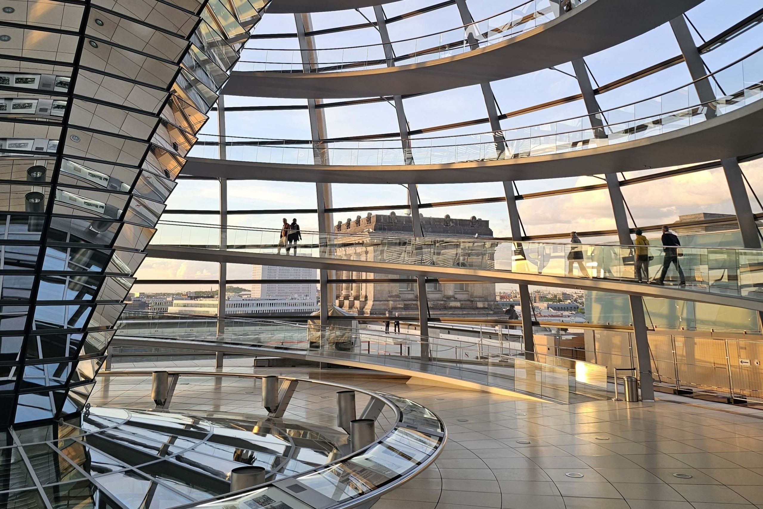 Reichstagskuppel im Abendlicht mit Blick auf das historische Reichstagsgebäude während des Sonnenuntergangs in Berlin