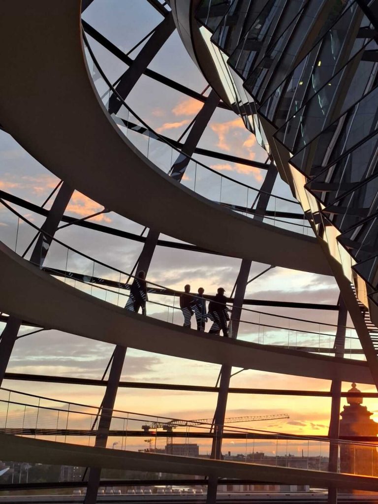 Besucher in der Reichstagskuppel bei Sonnenuntergang mit Blick über Berlin
