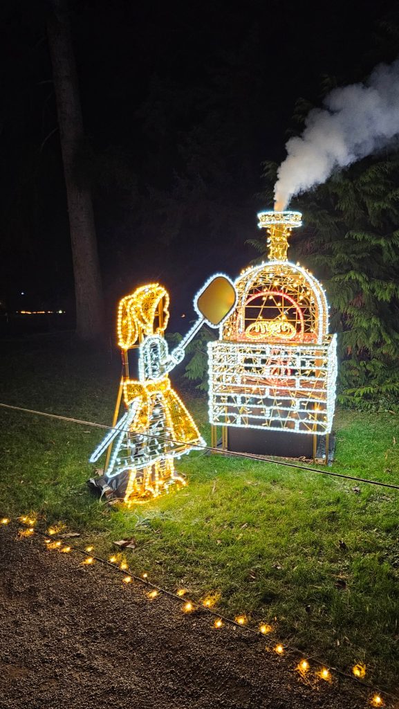 Leuchtende Märchenfigur vor einem Ofen beim Christmas Garden Mainau